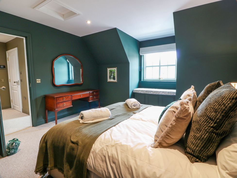 A bedroom with a bed and a table at Riverwood House in Gatehouse Of Fleet