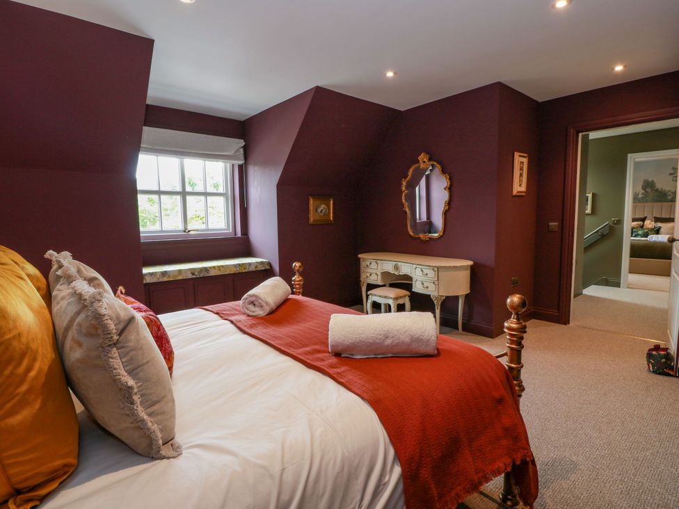 A bedroom with a bed and dressing table at Riverwood House in Gatehouse Of Fleet