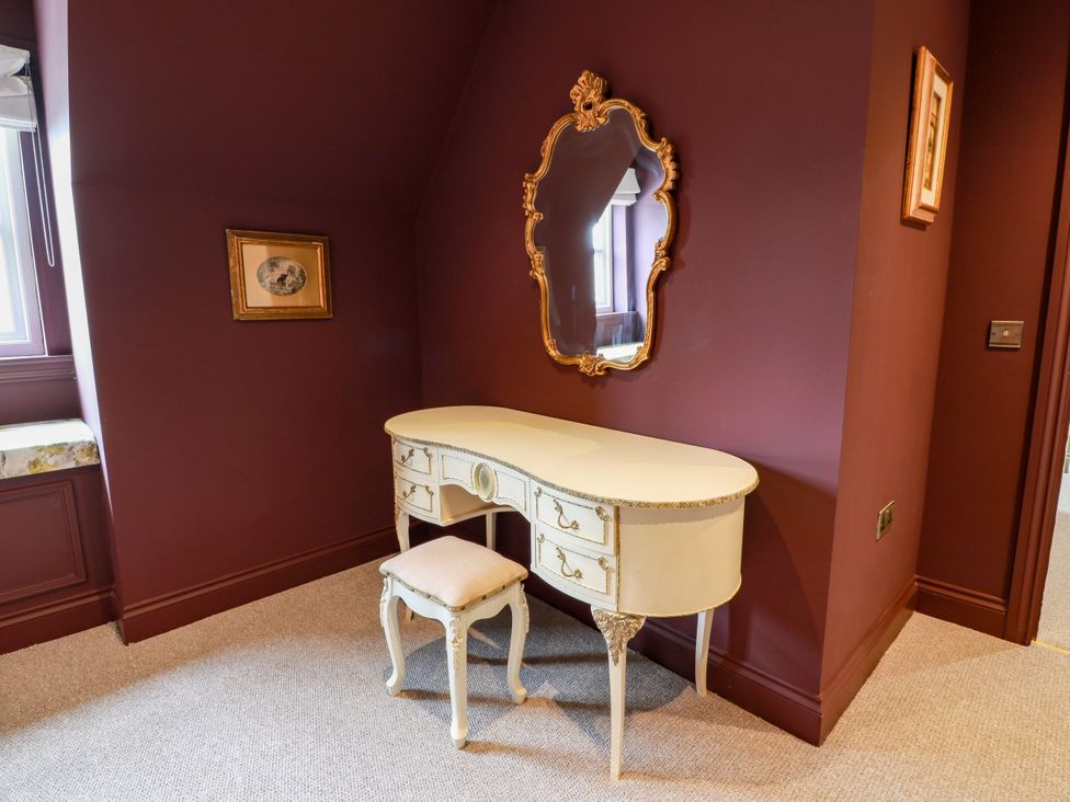 A vanity table with a mirror in a bedroom at Riverwood House in Gatehouse Of Fleet