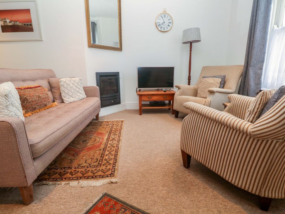 A living room with a sofa and television at Pelican Cottage in St Ives