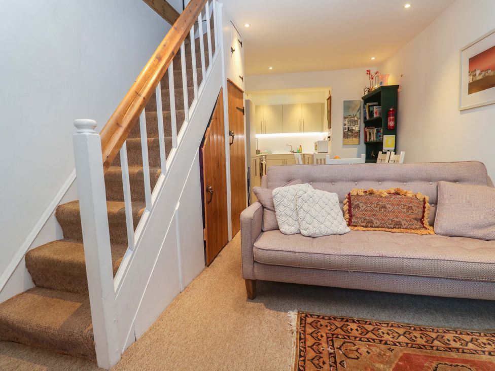 A living room with a staircase and a sofa at Pelican Cottage in St Ives