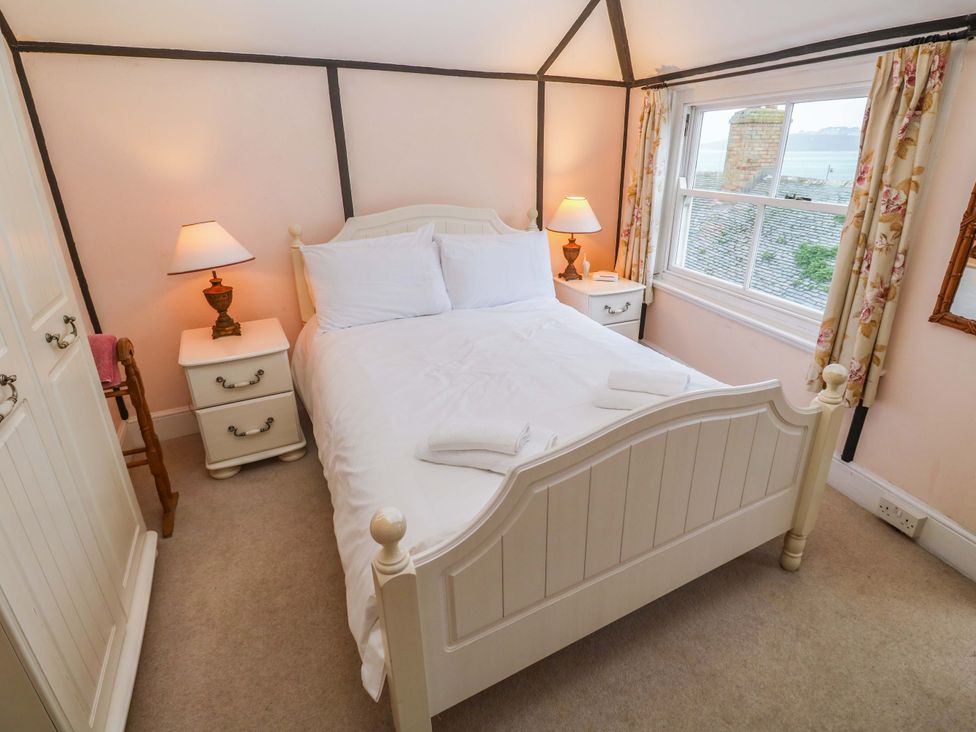 A bedroom with a bed and a window at Pelican Cottage in St Ives