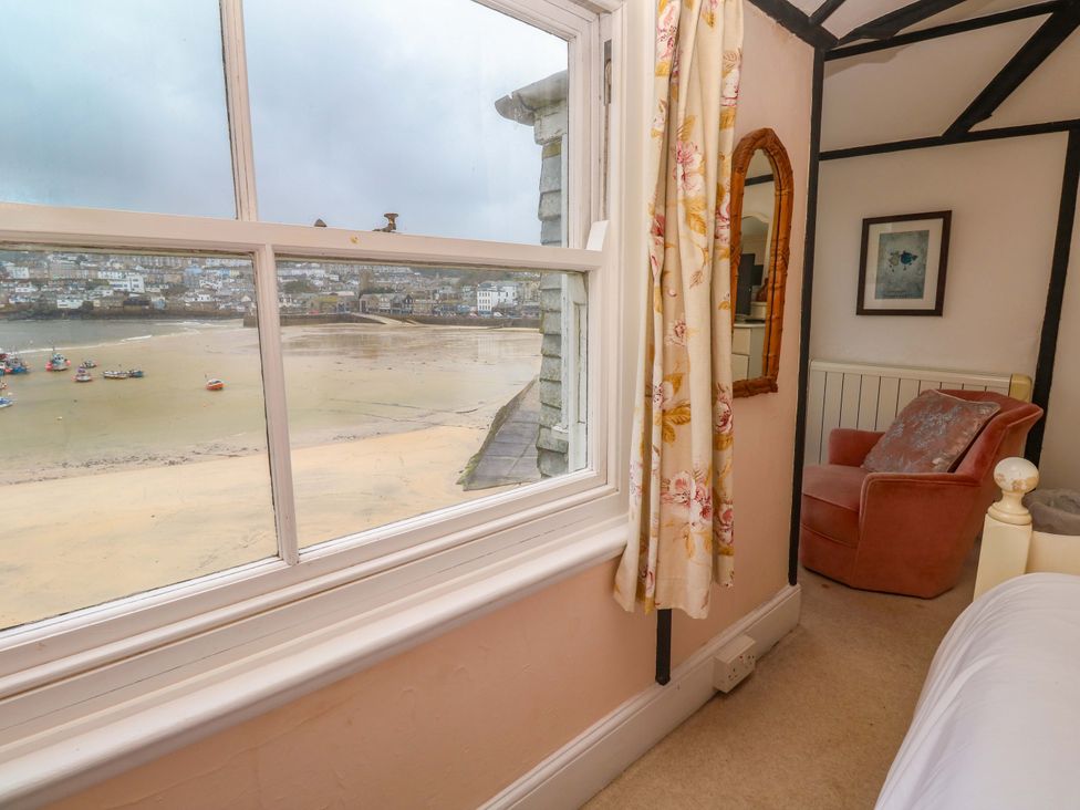 A bedroom with a view of the beach and boats at Pelican Cottage St Ives