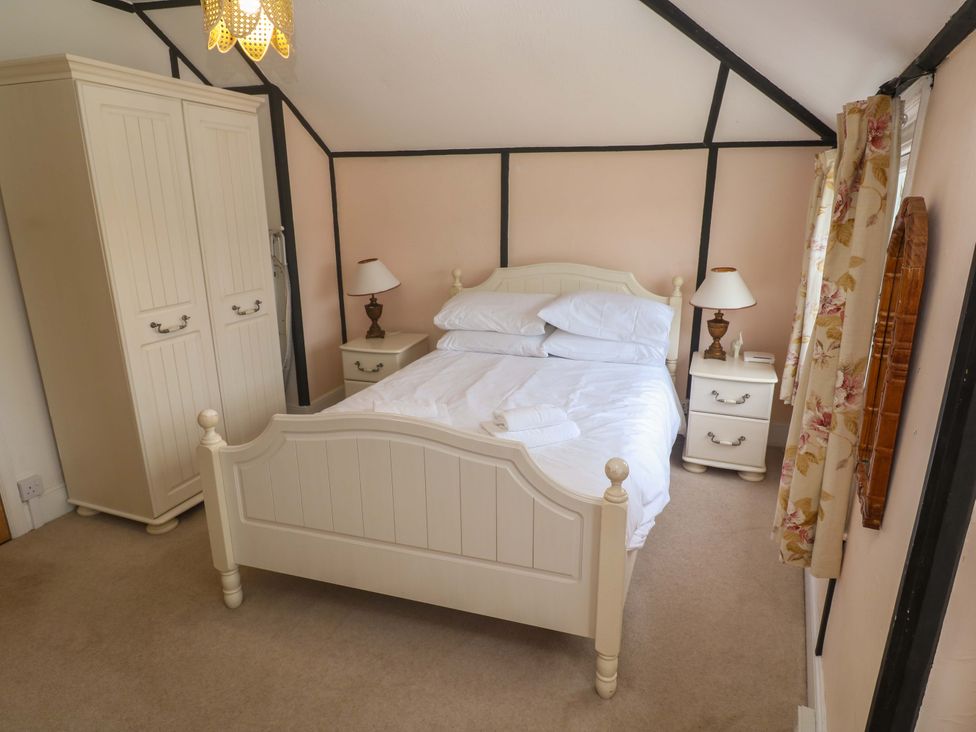 A bedroom with a bed and wardrobe at Pelican Cottage in St Ives