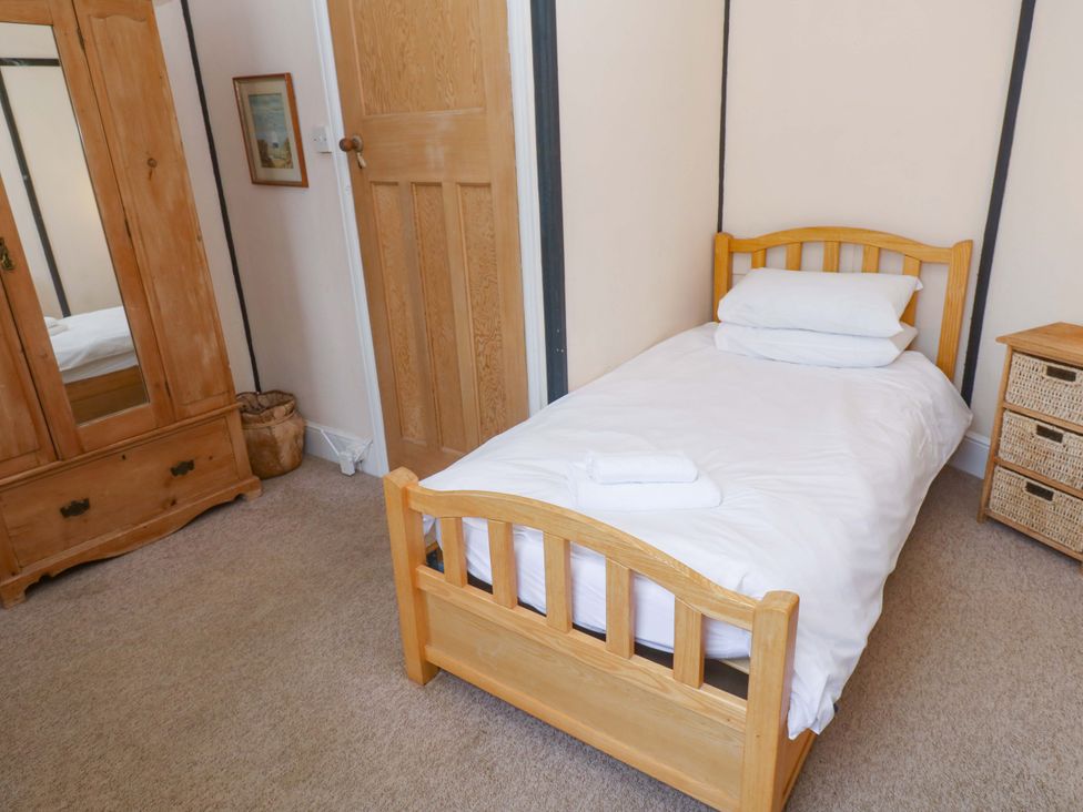 A bedroom with a single bed and wardrobe at Pelican Cottage St Ives