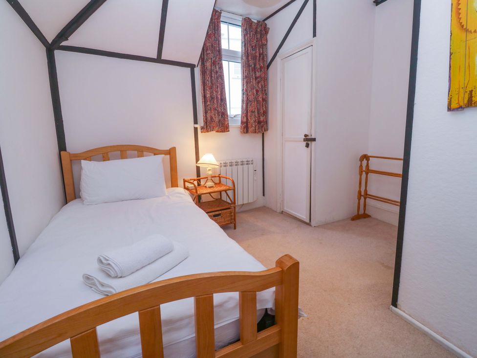 A bedroom with a single bed and bedside table at Pelican Cottage in St Ives