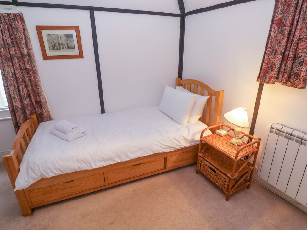 A bedroom with a single bed and lamp at Pelican Cottage in St Ives
