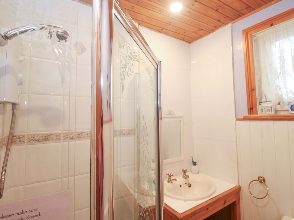 A bathroom with a shower and sink at Pelican Cottage St Ives