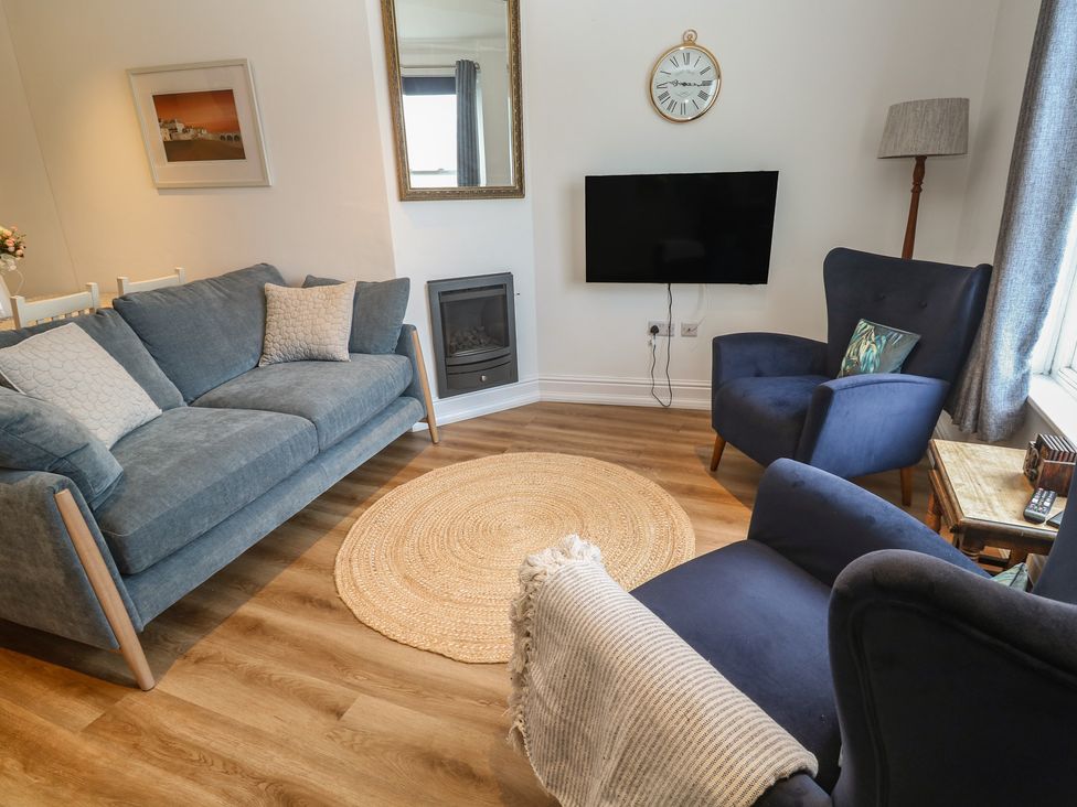 A living room with a sofa and television at Pelican Cottage St Ives