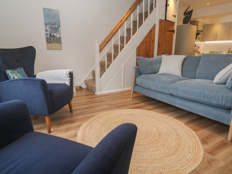 A living room with a sofa and chairs at Pelican Cottage St Ives