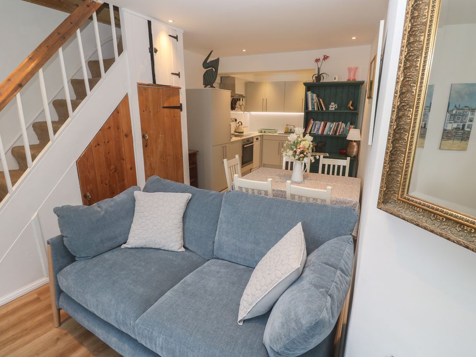 A living room with a couch and dining table at Pelican Cottage in St Ives
