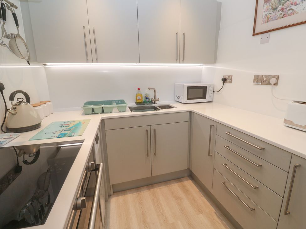 A kitchen with a sink and microwave at Pelican Cottage in St Ives