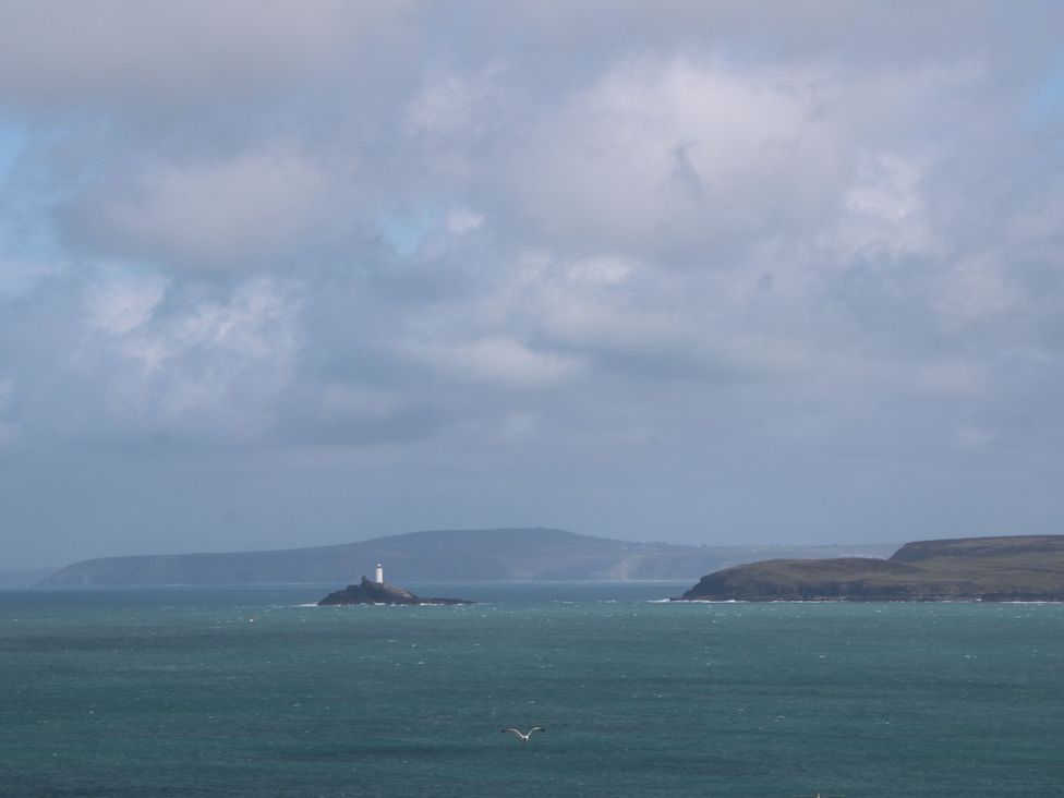 A view of a lighthouse on an island surrounded by ocean at Crows Nest St Ives