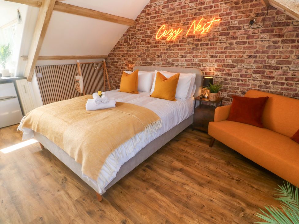 A bedroom with a bed and sofa at Seagulls Nest in St Ives