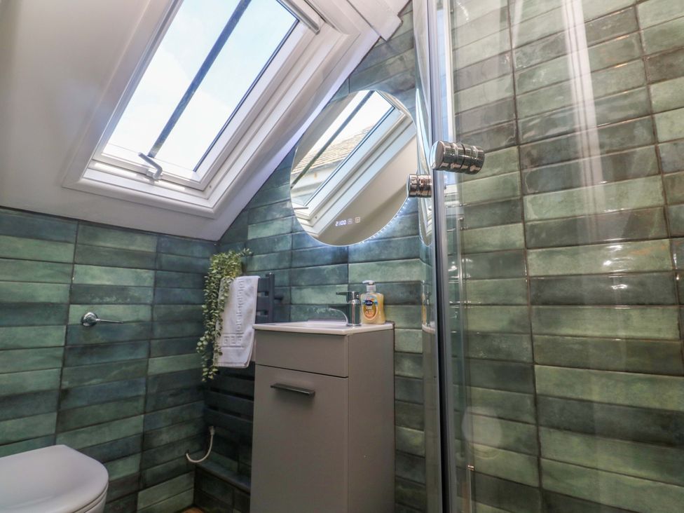 A bathroom with a shower, sink, and a toilet at Seagulls Nest in St Ives