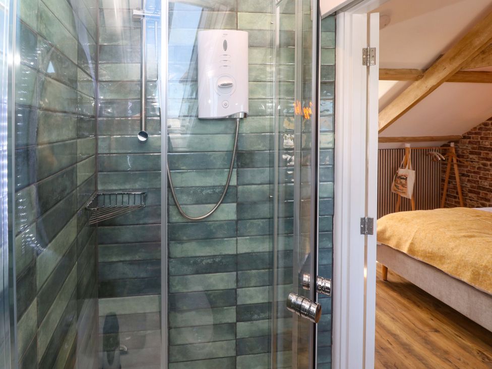 A shower with glass enclosure and tiles at Seagulls Nest in St Ives