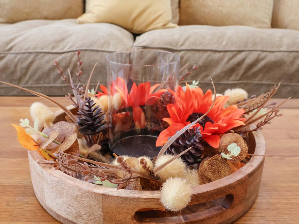 A wooden tray with a glass vase and artificial flowers at Sandy Nook in Redcar