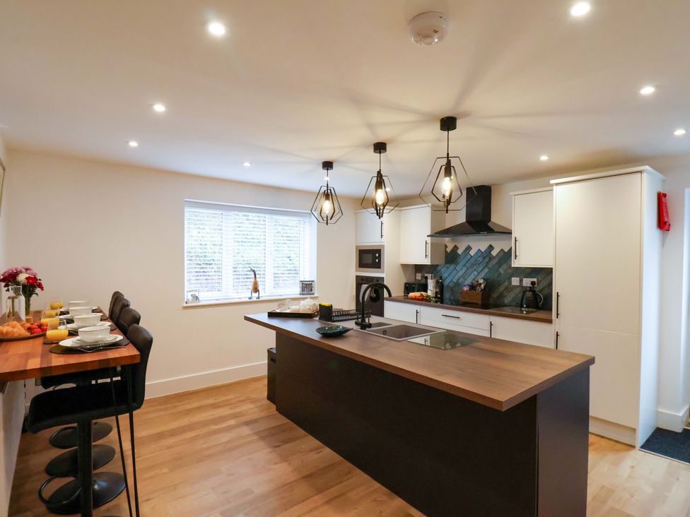 A kitchen with a kitchen island and stools at Sandy Nook in Redcar