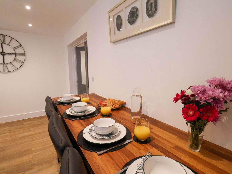 A dining table set with dishes and flowers at Sandy Nook in Redcar