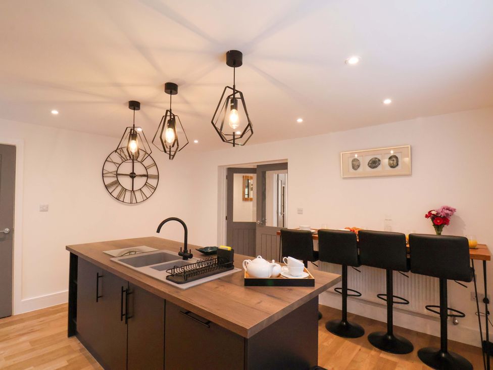 A kitchen with a central island and bar stools at Sandy Nook in Redcar