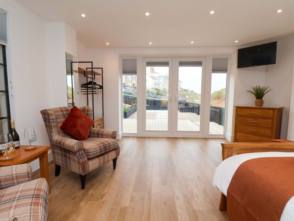 A bedroom with seating and a television at Sandy Nook in Redcar
