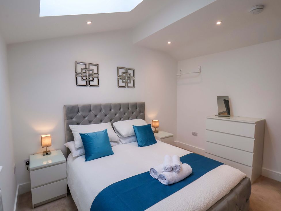 A bedroom with a bed and bedside tables at Sandy Nook in Redcar