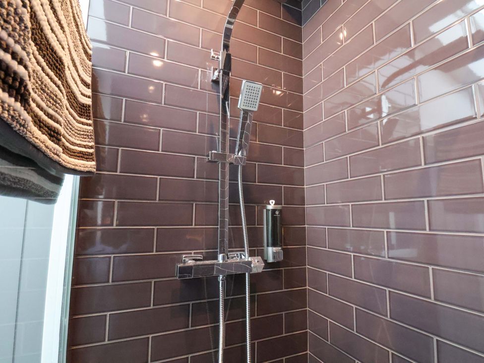 A shower with tile walls and a soap dispenser at Sandy Nook in Redcar