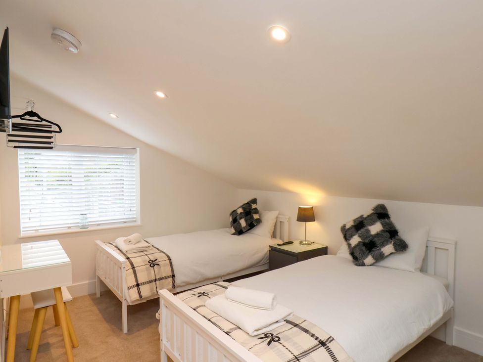 A bedroom with two single beds and a television at Sandy Nook in Redcar