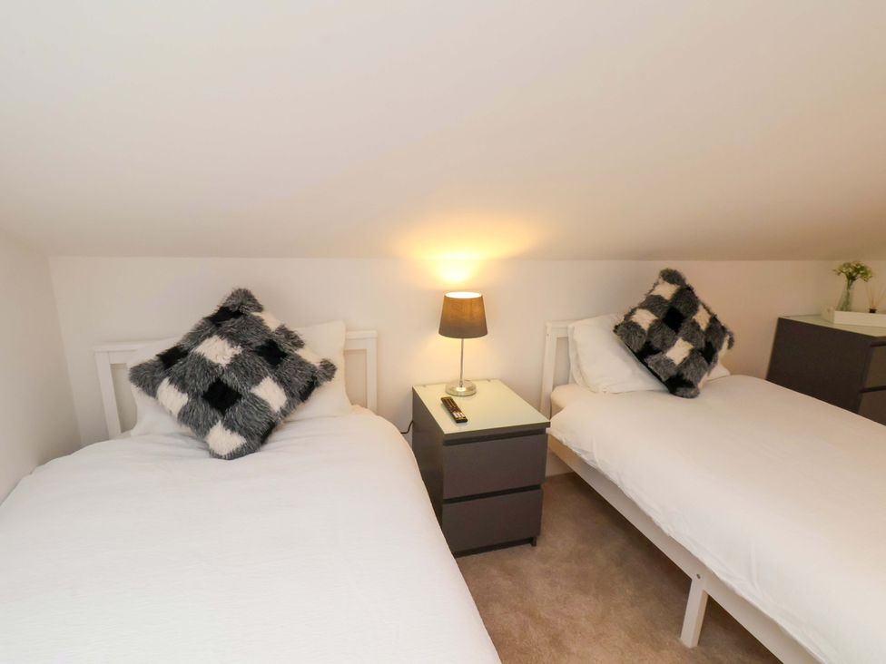 A bedroom with two beds and a lamp at Sandy Nook in Redcar