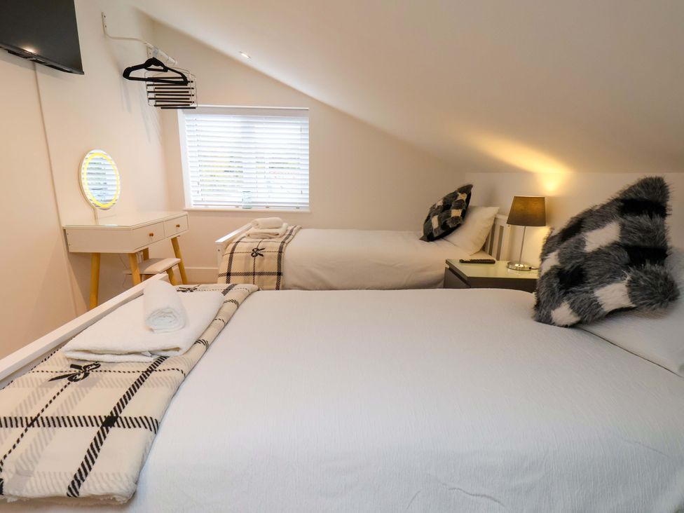 A bedroom with two beds and a television at Sandy Nook in Redcar