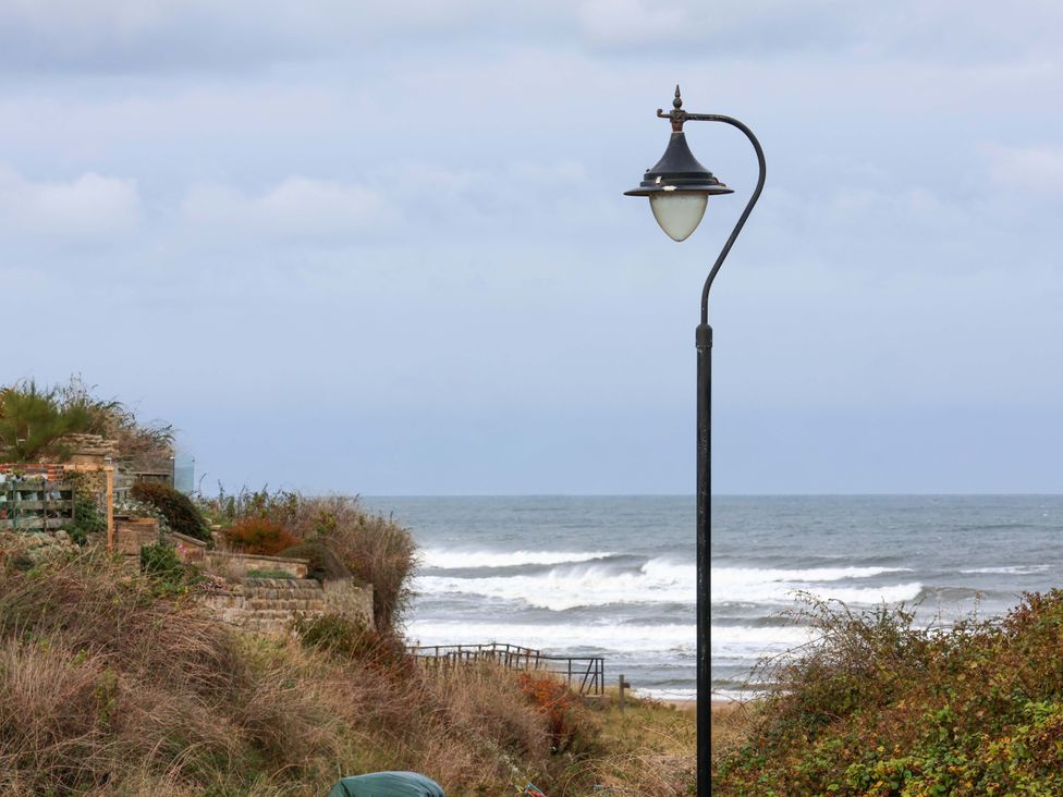 A lamp post near the ocean with waves at Sandy Nook in Redcar