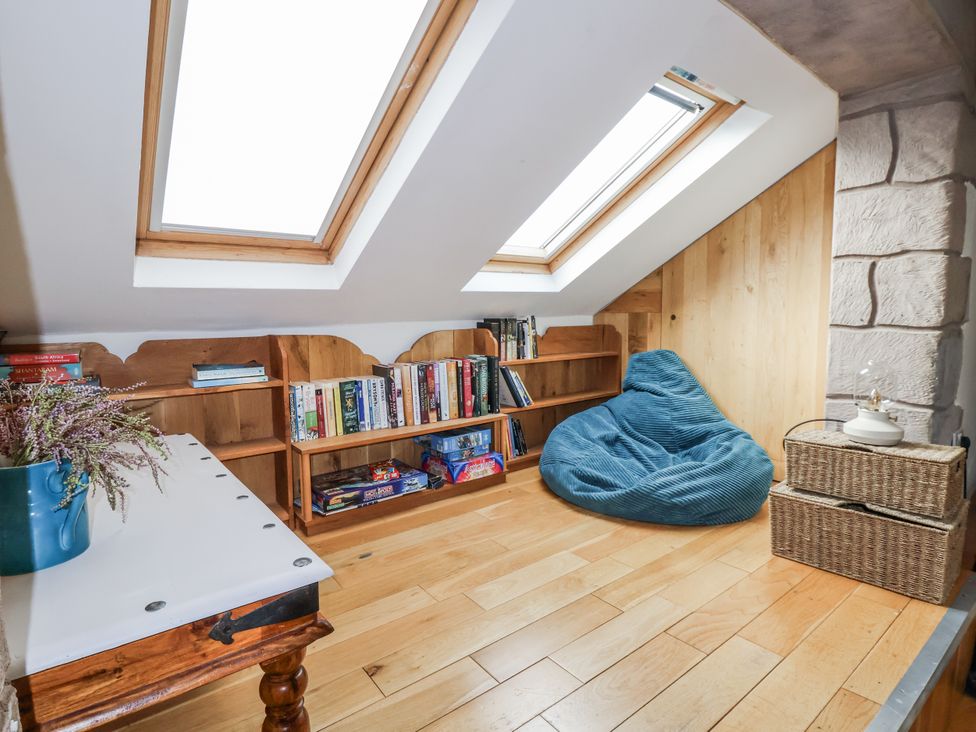 A snug with a bookshelf and bean bag at The Hayloft in Bodelwyddan