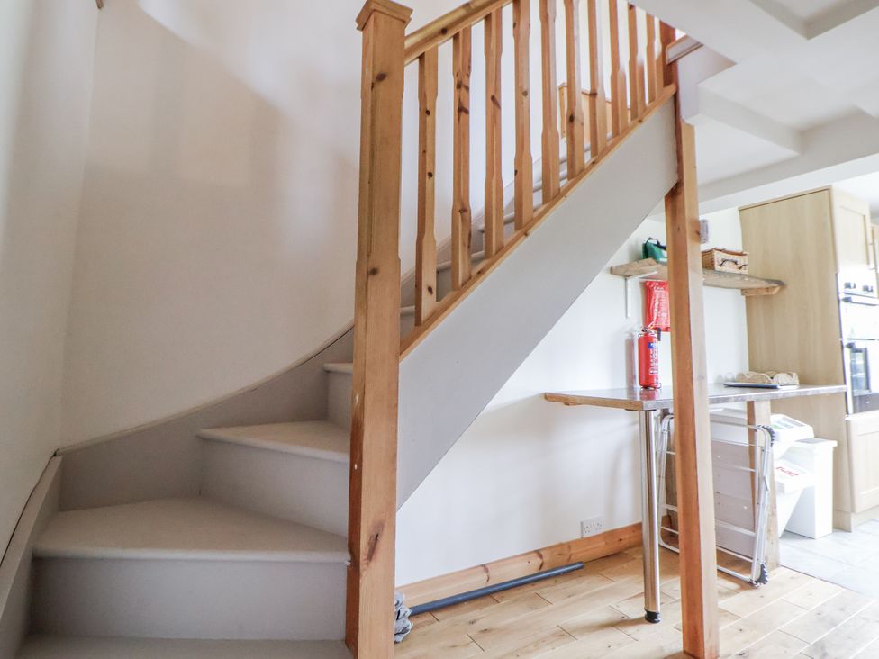 A staircase and kitchenette area at The Hayloft in Bodelwyddan