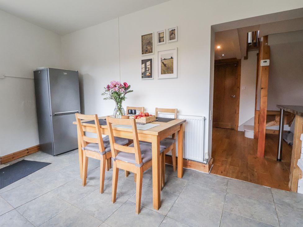 A kitchen with a dining table and chairs at The Hayloft in Bodelwyddan