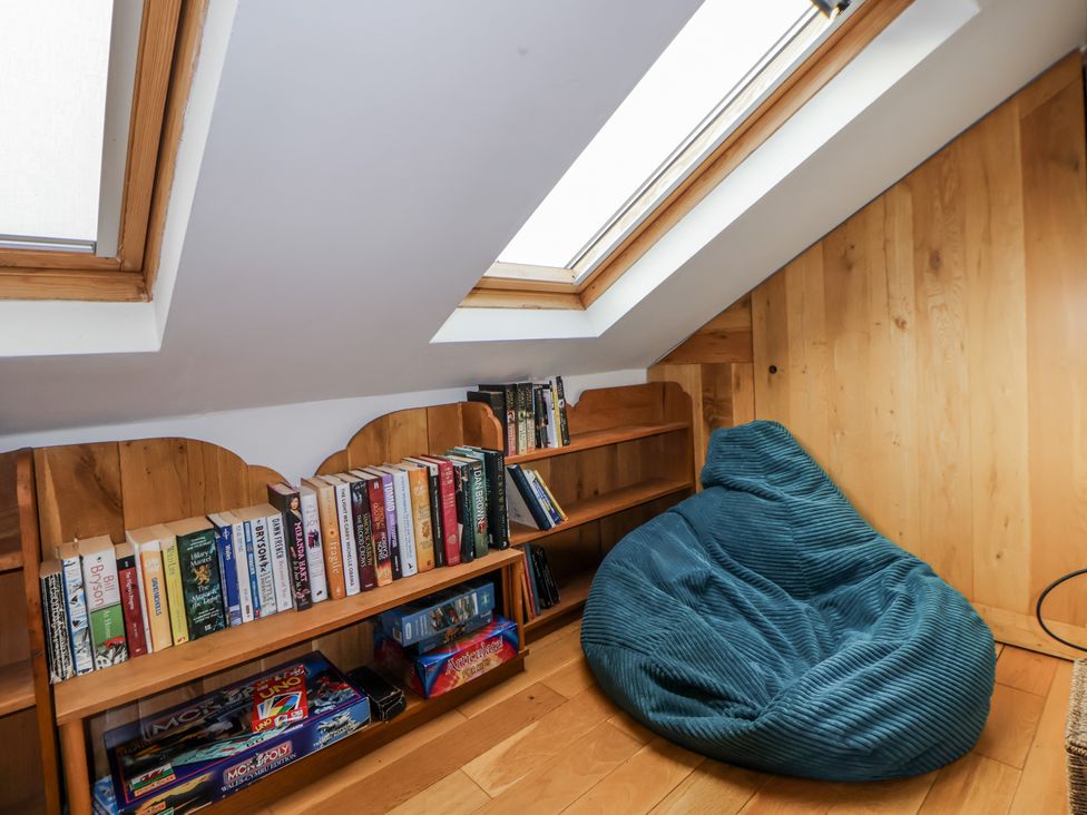 A reading nook with bookshelves and a bean bag at The Hayloft in Bodelwyddan