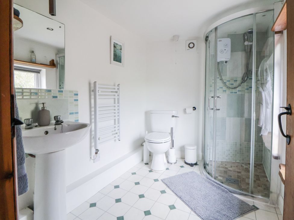 A bathroom with a shower, sink, and toilet at The Hayloft in Bodelwyddan