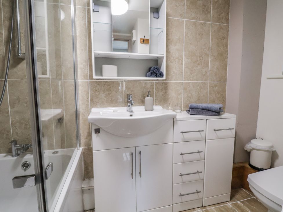 A bathroom with a sink, bathtub, and shower at The Hayloft in Bodelwyddan