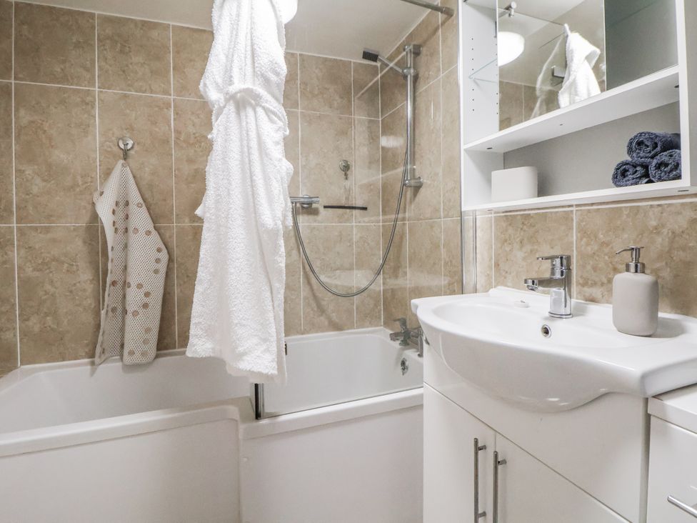 A bathroom with a bathtub and sink at The Hayloft in Bodelwyddan