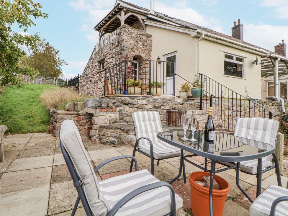 An outdoor seating area with a table and chairs at The Hayloft in Bodelwyddan