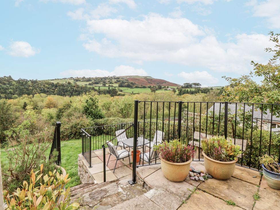 A garden with seating and planters at The Hayloft in Bodelwyddan