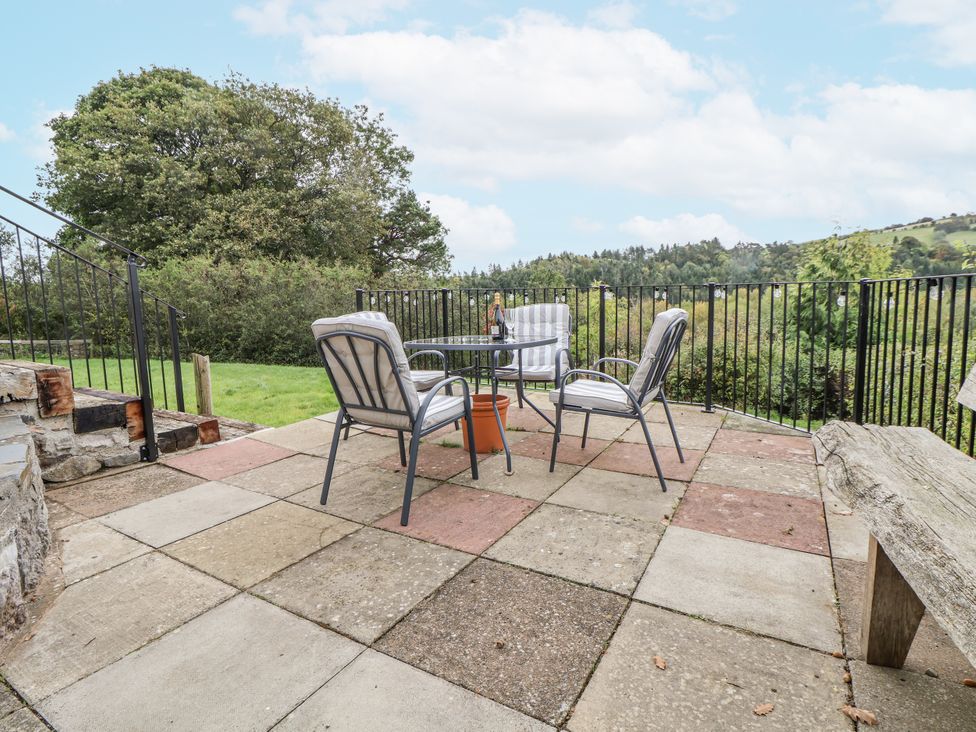 A patio with a table and chairs at The Hayloft in Bodelwyddan