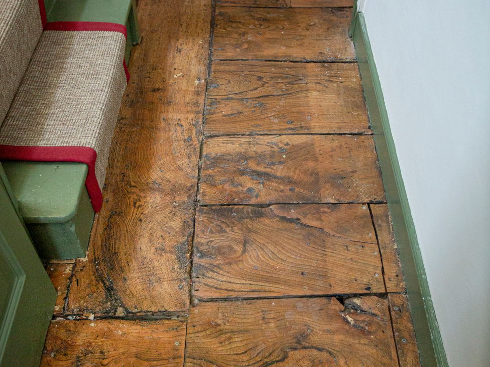 A wooden floor with an armchair in a hallway at Apartment 2, 86 Dyer Street Cirencester