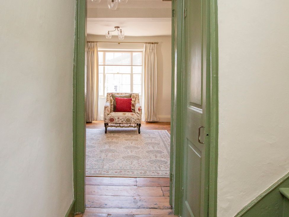 A living room with a chair and window at Apartment 2, 86 Dyer Street Cirencester
