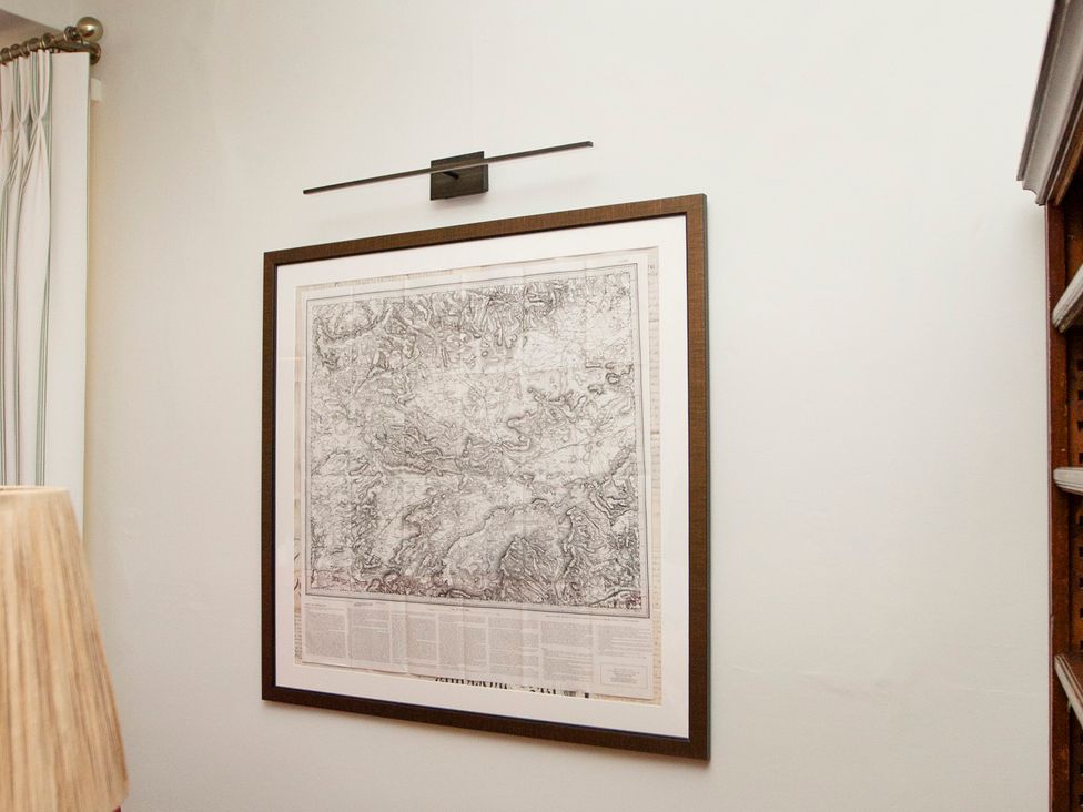 A wall with a framed map and light fixture at Apartment 2, 86 Dyer Street Cirencester