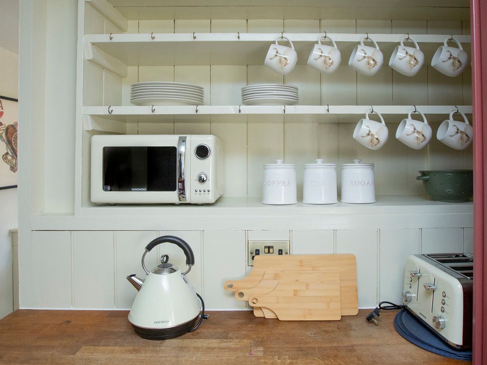 A kitchen with a microwave kettle and toaster at Apartment 2, 86 Dyer Street Cirencester