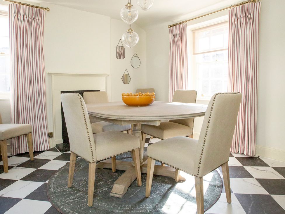 A dining room with a round table and chairs at Apartment 2, 86 Dyer Street Cirencester