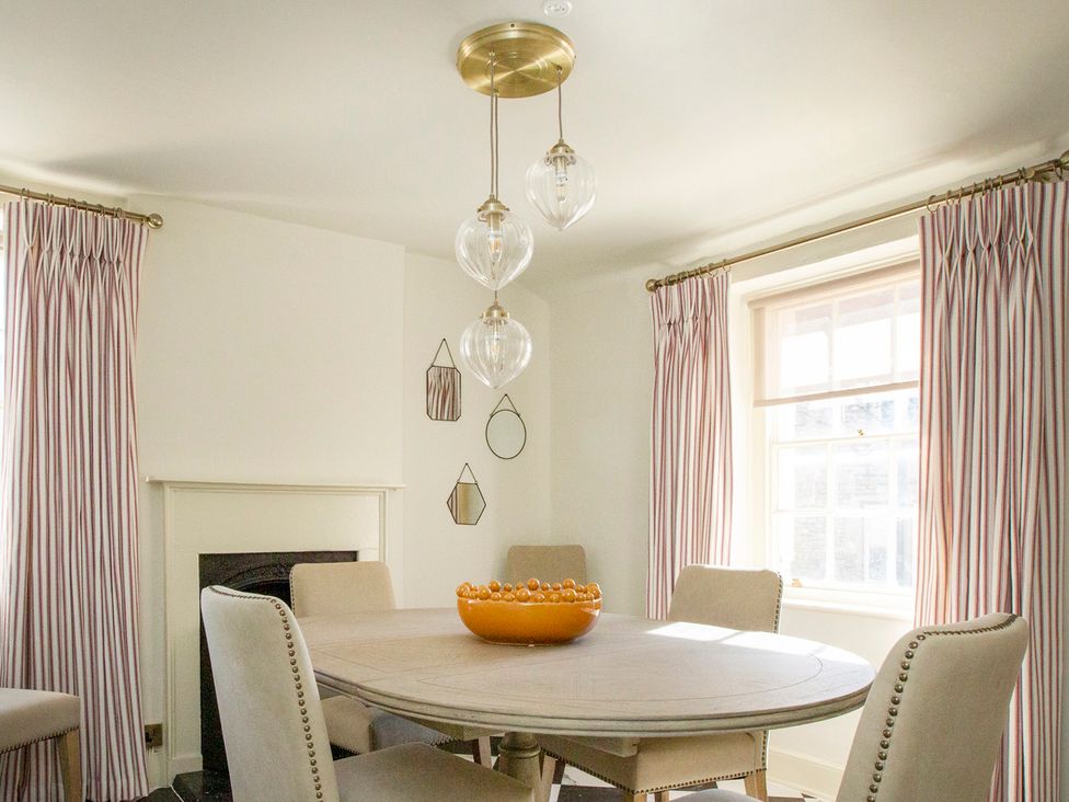 A dining room with a round table and chairs at Apartment 2, 86 Dyer Street Cirencester