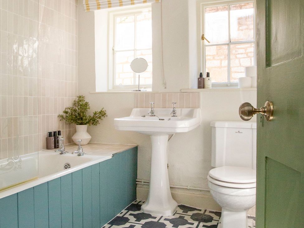 A bathroom with a bathtub, sink, and toilet at Apartment 2, 86 Dyer Street, Cirencester