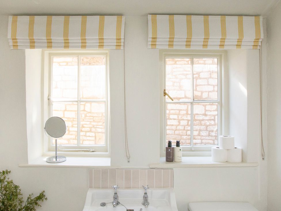 A bathroom with sinks and windows at Apartment 2, 86 Dyer Street Cirencester