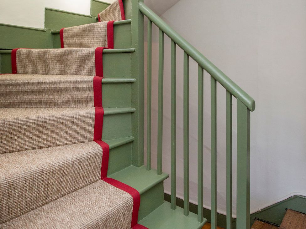 A staircase with carpet and handrail at Apartment 2, 86 Dyer Street Cirencester